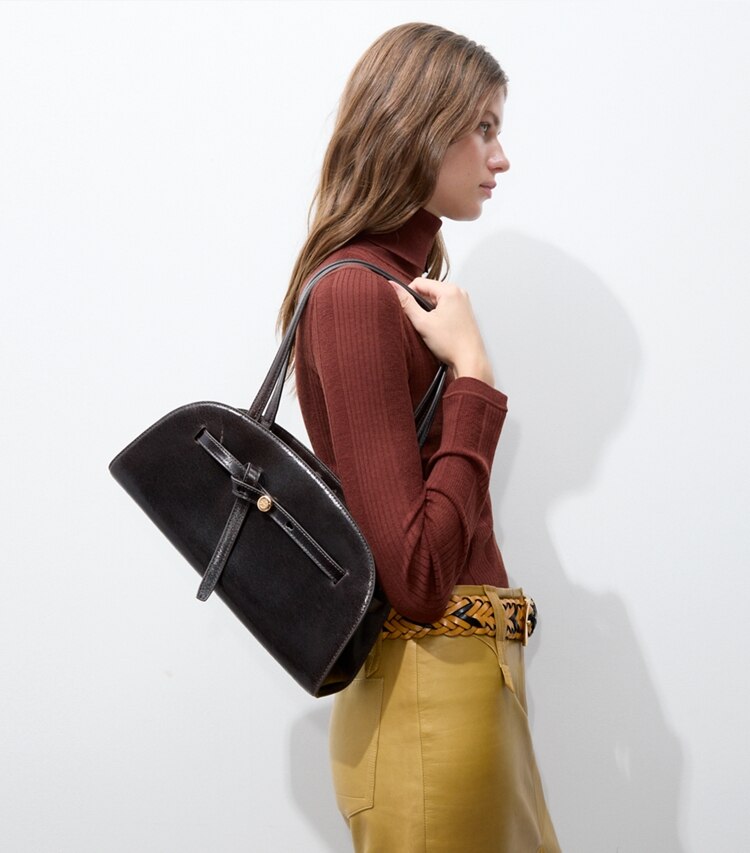 Tory Burch diseñador bolsos de hombro Bauletto con efecto desgastado Romy East West en Dark Brown accesorio en modelo