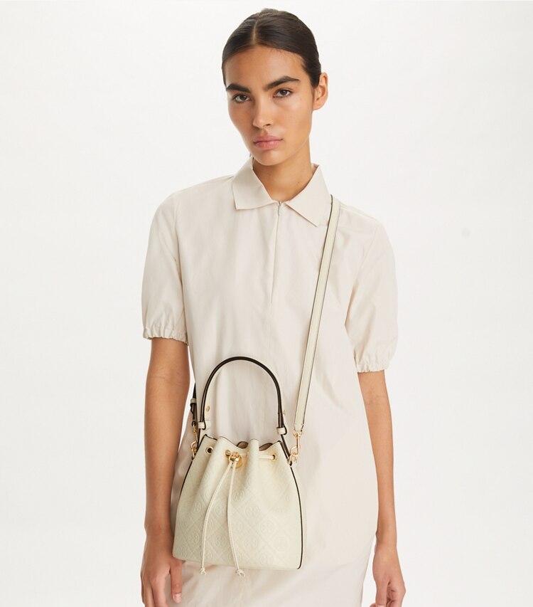 Tory Burch designer crossbody bags Bucket Bag mit geprägtem T-Monogramm in Light Cream accessory on model