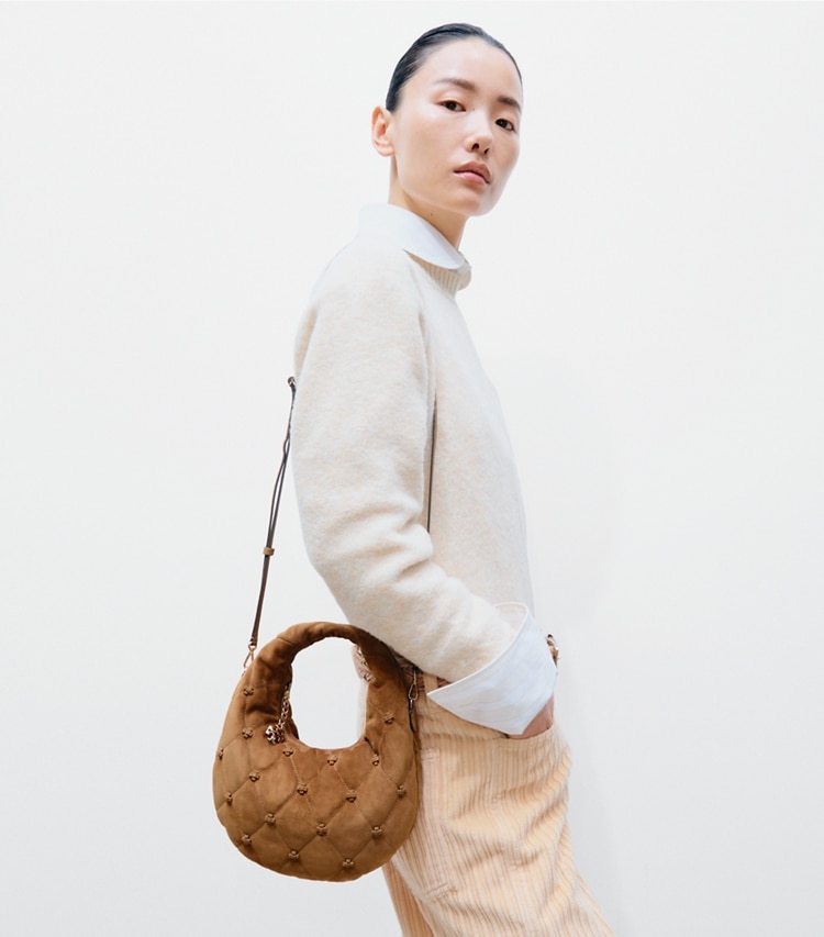 Tory Burch designer crossbody bags Bunny Knot Suede Crescent Bag in Toffee accessory on model