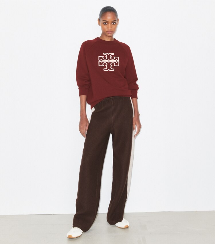 Tory Burch designer sweaters Chandail à col rond à logo en molleton épais dans Dark Sangria sur modèle, de face