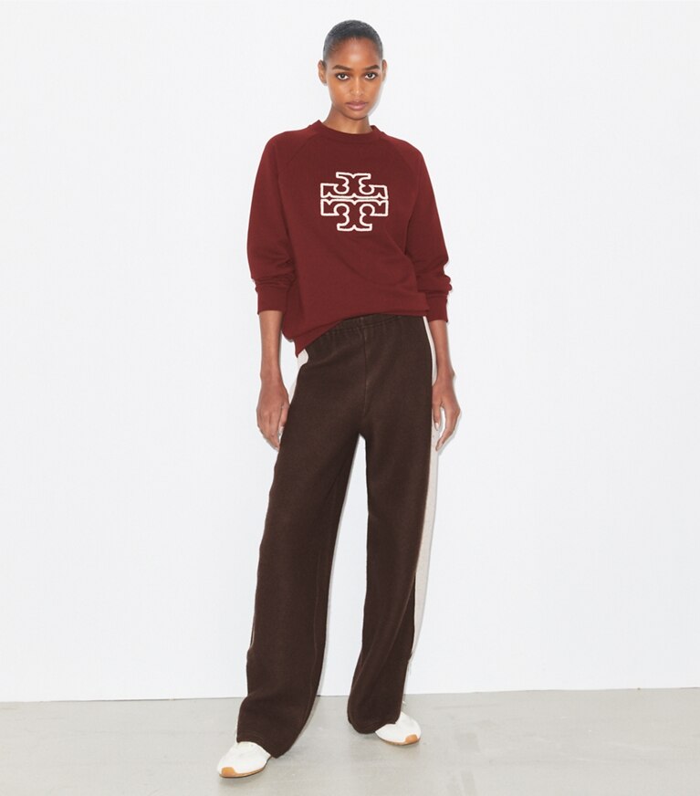 Tory Burch designer sweaters Chandail à col rond à logo en molleton épais dans Dark Sangria sur modèle, de face