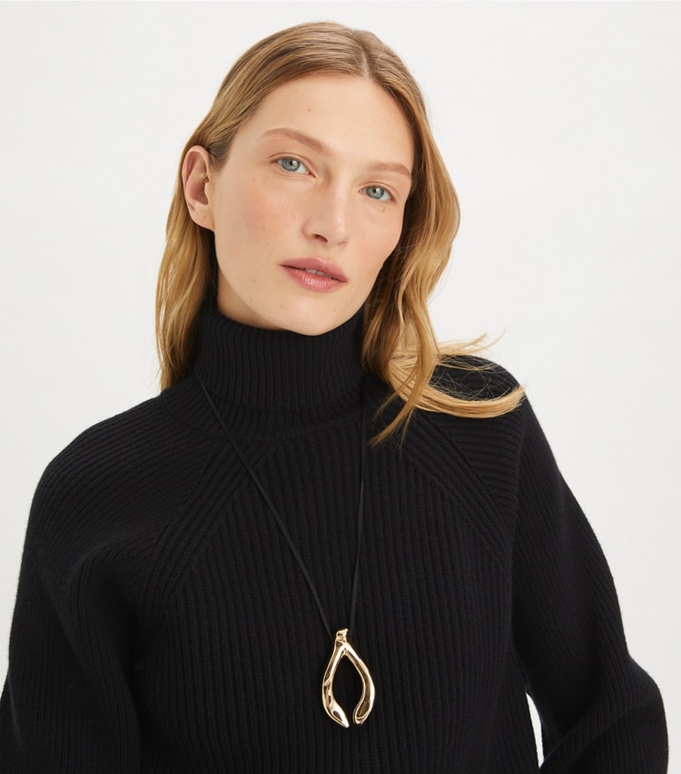 Tory Burch designer collane Ciondolo Wishbone in Light Brass / Black accessory on model
