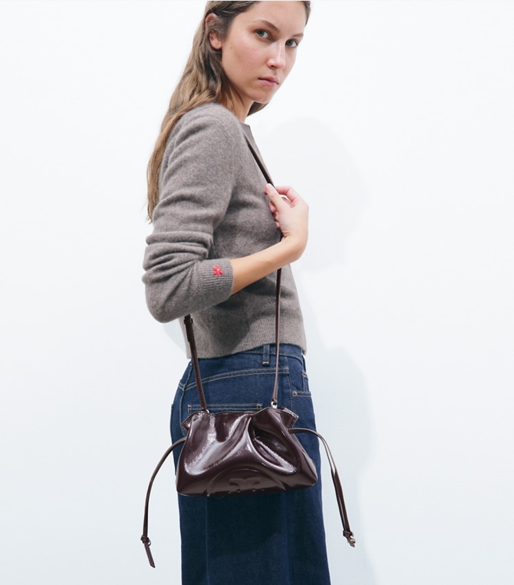 Tory Burch designer crossbody bags Ella Distressed Drawstring Pouch in Mulberry accessory on model