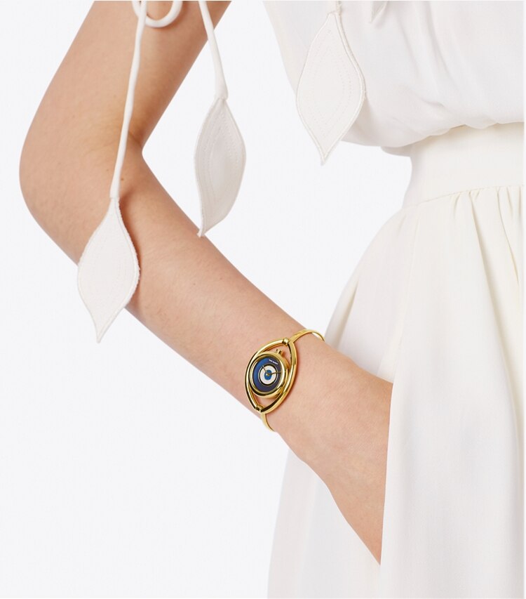 Tory Burch designer strap watches Evil Eye Bangle Watch, Gold-Tone/Ivory, 25 MM in Gold/Navy accessory on model