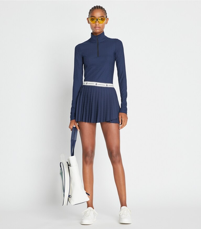 Tory Sport diseñador prendas inferiores Falda con sobrefalda plisada de jersey de jacquard de alto rendimiento en Tory Navy frente en modelo