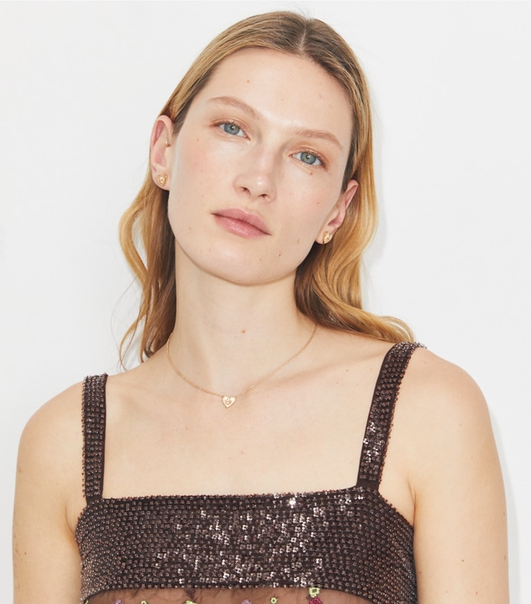 Tory Burch designer earrings Forget Me Not Heart Stud Earrings in Tory Gold accessory on model