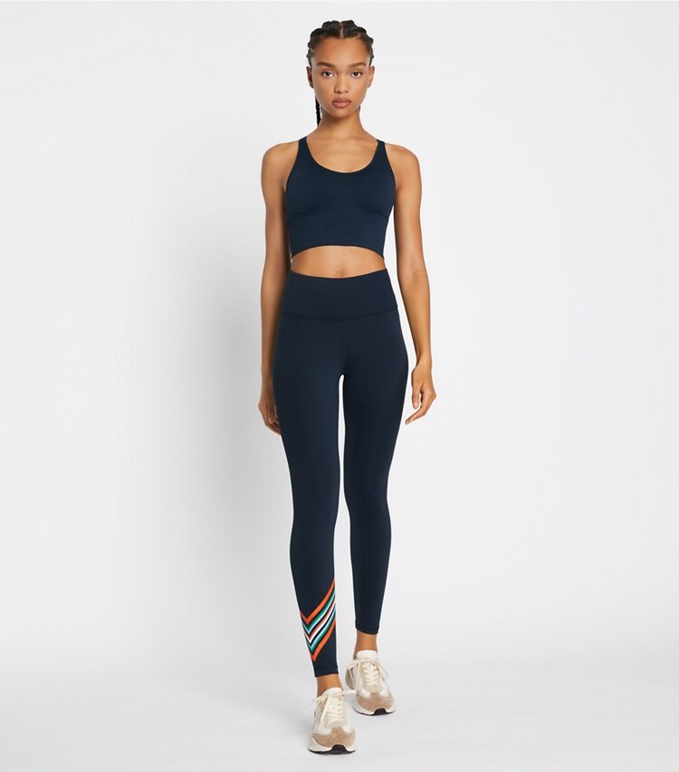 Tory Sport designer bottoms High-Rise Weightless Spectrum Chevron Legging in Tory Navy / Red on model front