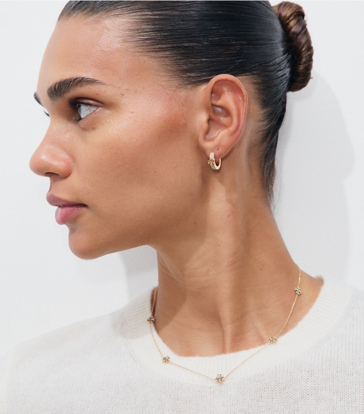 Tory Burch designer earrings Icon Pavé Huggie Earrings in Tory Gold / Crystal accessory on model