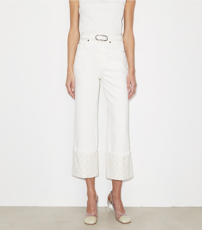 Tory Burch designer unterteile Jeans mit T-Monogramm, kontrastierendem Umschlag und geradem Beinschnitt in White on model detail