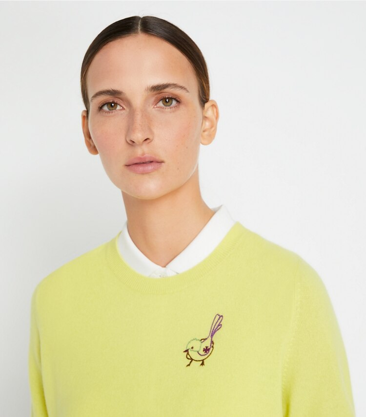Tory Sport diseñador suéteres Jersey raglán de cachemira con pajarito en Lemon Glow en el modelo (detalle)
