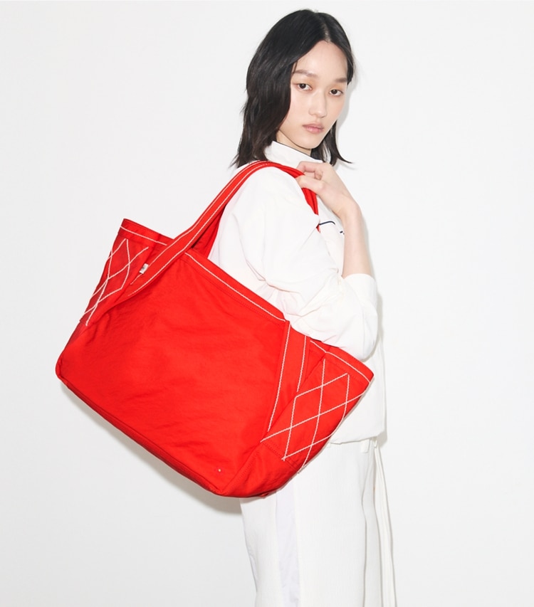 Tory Burch designer tote bags Jet Lag Tote in Red Jasmine accessory on model