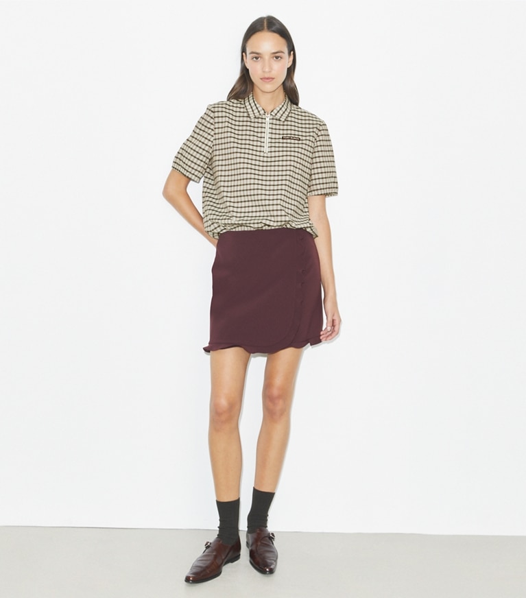 Tory Burch designer bas Jupe de golf extensible à volants dans Dark Sangria sur modèle, de face