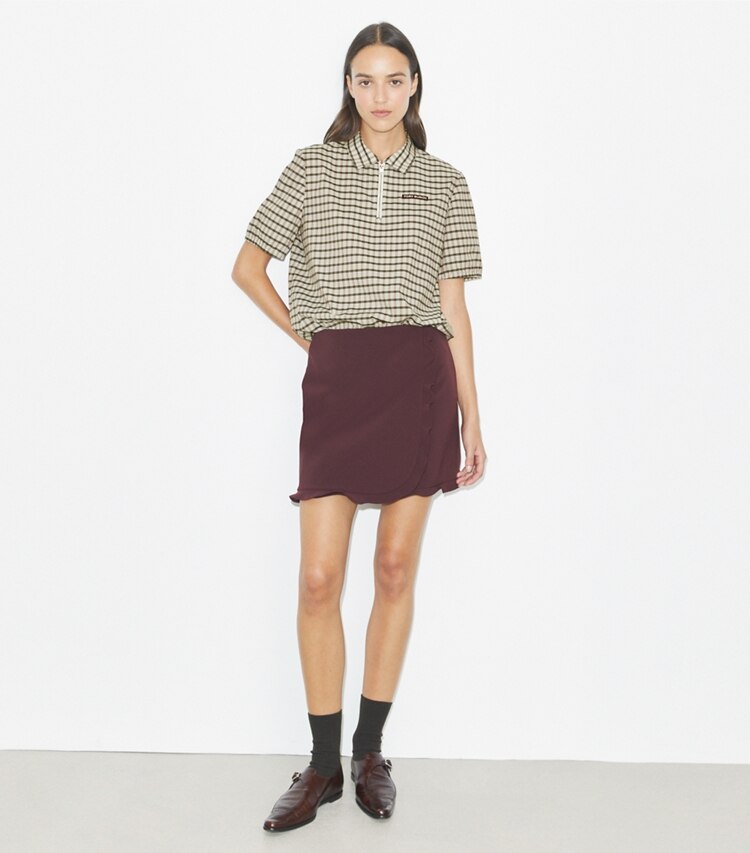 Tory Burch designer bas Jupe de golf extensible volantée in Dark Sangria sur mannequin, devant