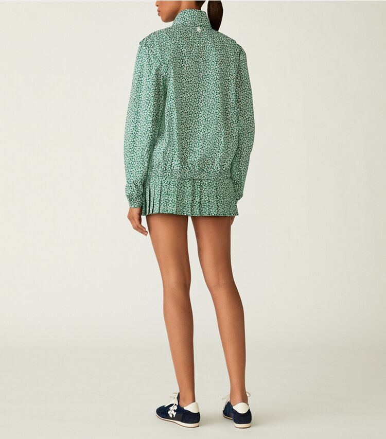 Tory Sport designer bas Jupe de tennis plissée imprimée in Evergreen Ditsy Daisy on model back