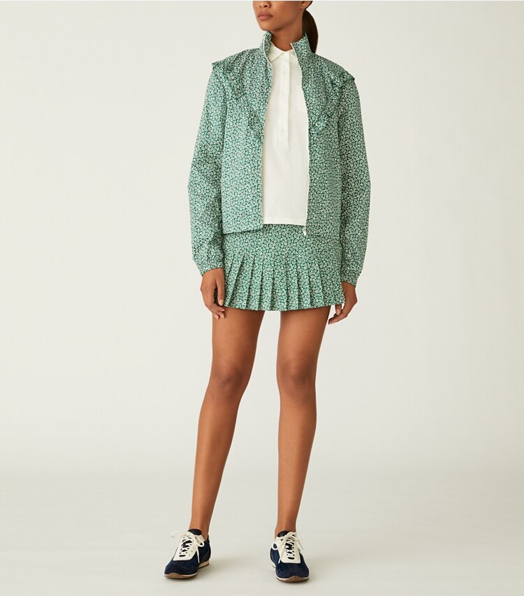 Tory Sport designer bas Jupe de tennis plissée imprimée in Evergreen Ditsy Daisy sur mannequin, devant