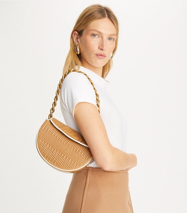 Tory Burch designer schultertaschen Kleine, weiche und plissierte Fleming Crescent Bag in DUSTY ALMOND accessory on model
