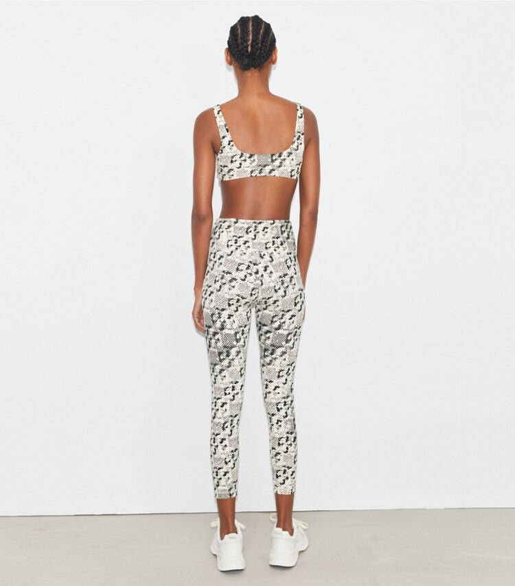 Tory Sport designer bas Legging 7/8 Weightless imprimé à taille haute in New Ivory Distressed Pixelated Logo on model back