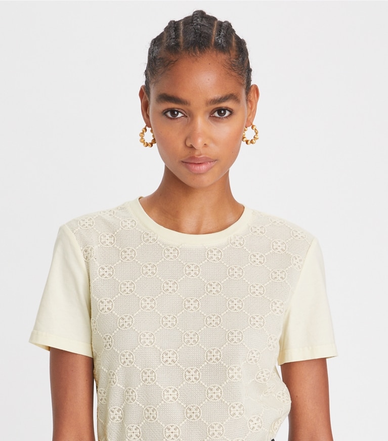 https://s7.toryburch.com/is/image/ToryBurch/style/logo-lace-t-shirt-on-model-detail.TB_148460_104_20230118_OMDET.pdp-767x872.jpg
