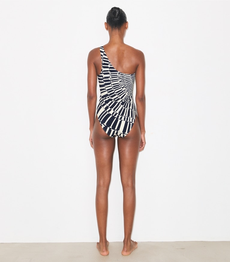 Tory Burch designer une pièce Maillot de bain asymétrique dans Medium Navy Circle T sur modèle, de dos