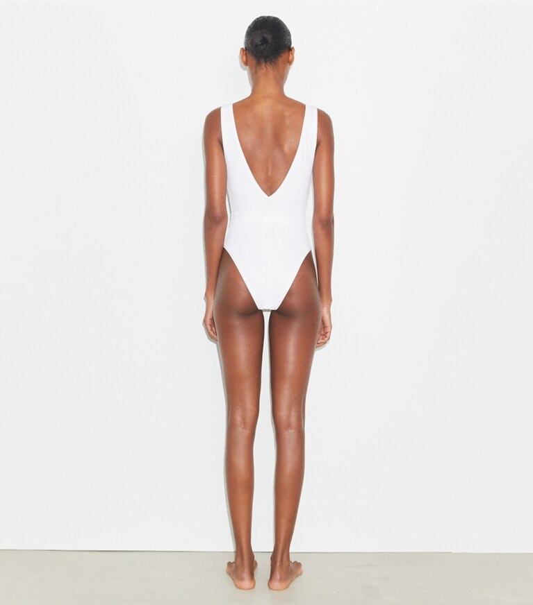 Tory Burch designer une pièce Maillot de bain ceinturé à logo dans White sur modèle, de dos