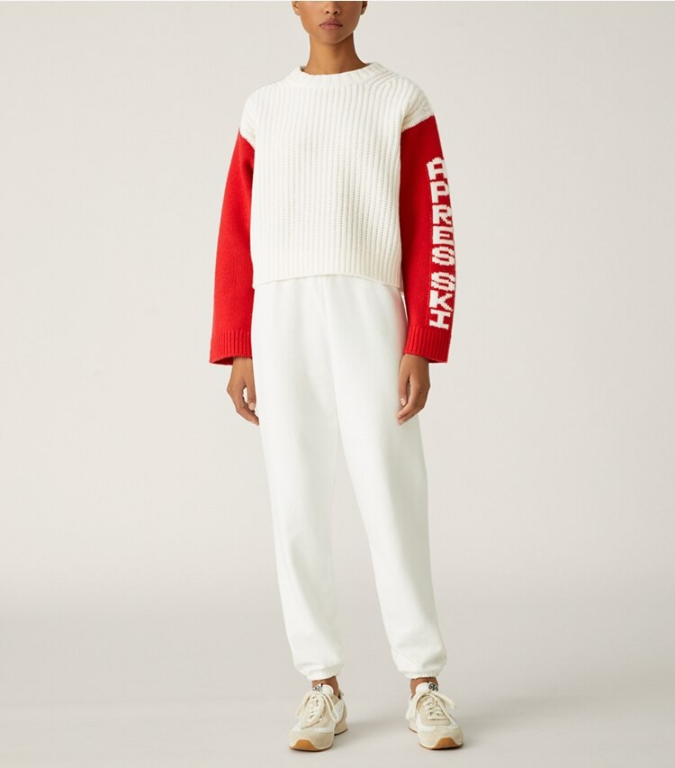 Tory Sport designer sweaters Merino Aprés Ski Sweater in Snow White / Red on model front