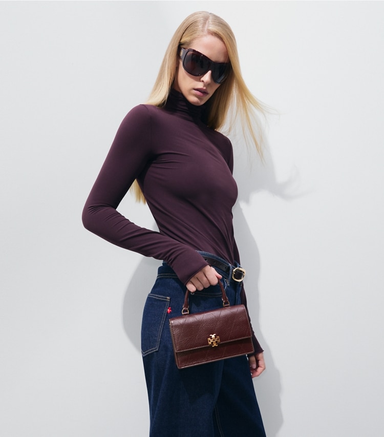 Tory Burch designer crossbody bags Mini Charlie Quilted Top-Handle Bag in Vintage Bordeaux accessory on model