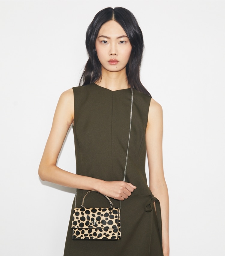 Tory Burch designer mini bags Mini Kira Calf Hair Top-Handle Crossbody in TRENCH / Black accessory on model