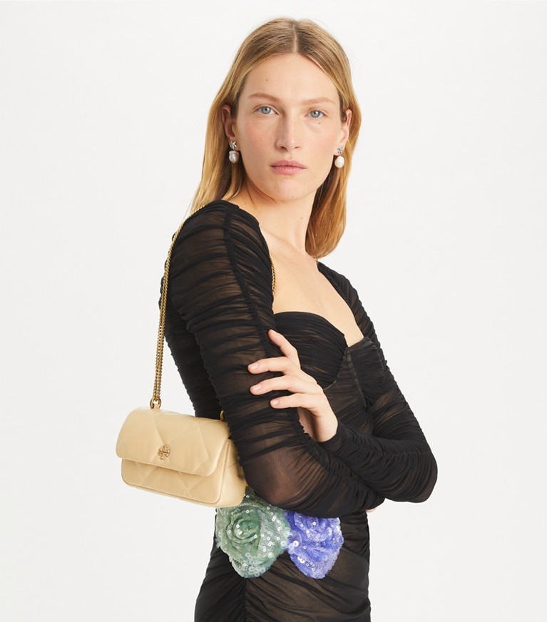 Tory Burch designer crossbody bags Mini Kira Diamond Quilt Pavé Logo Flap Bag in Vanilla Soft Serve accessory on model