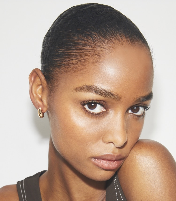 Tory Burch designer earrings Mini Pierced Earrings in Light Brass accessory on model