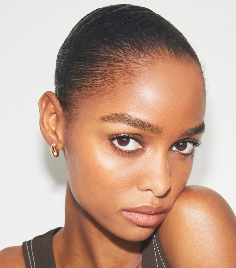Tory Burch designer earrings Mini Wave Earring in Light Brass accessory on model