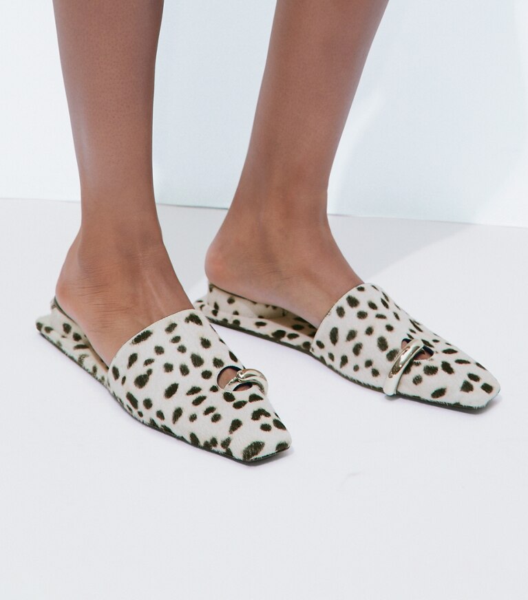 Tory Burch designer mocassins Mules effet piercing in Black / White accessory on model