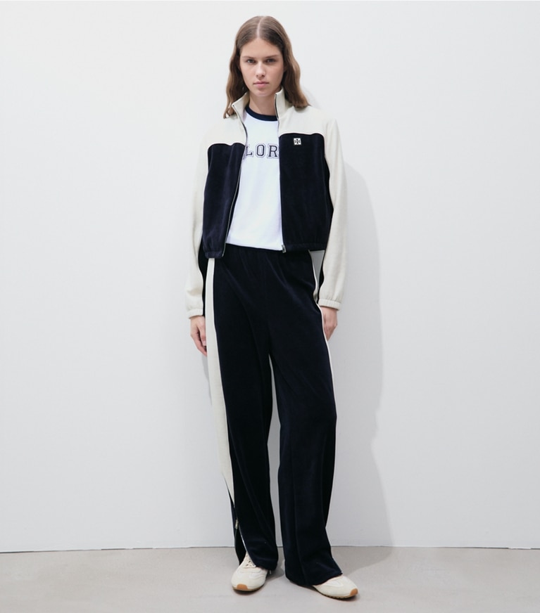 Tory Burch diseñador prendas de abajo Pantalón de chándal de terciopelo con bloques de color en Medium Navy / New Ivory frente en modelo