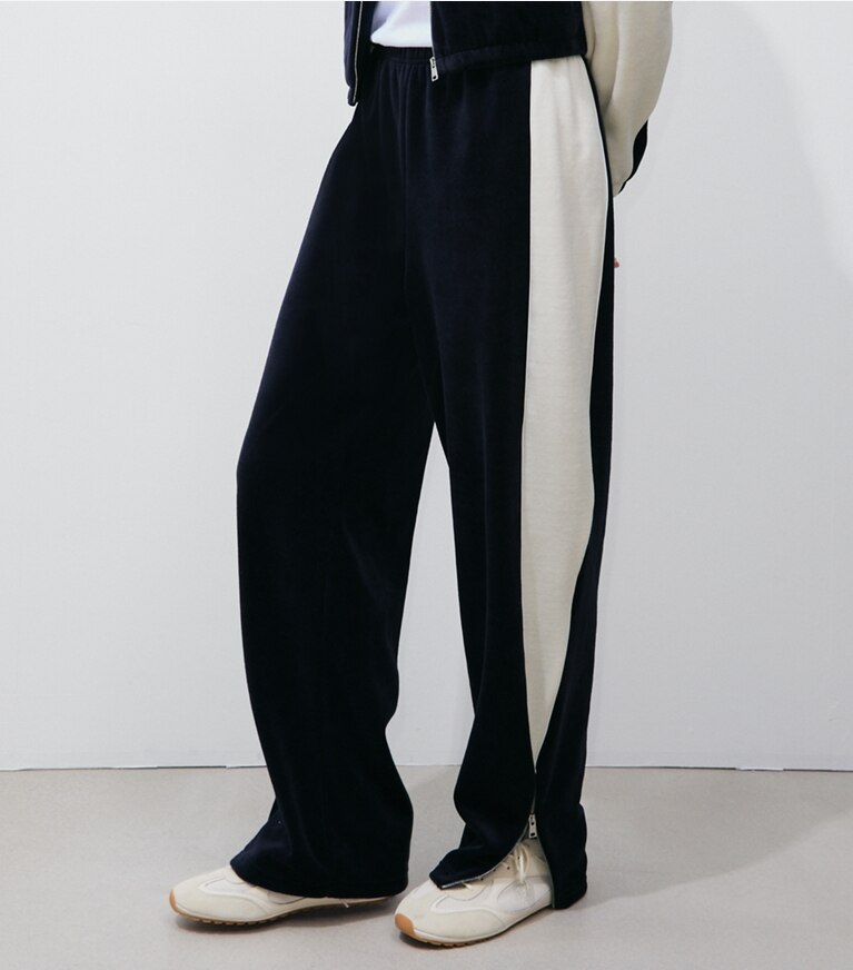 Tory Burch designer bas Pantalon d’entraînement en velours à blocs de couleurs dans Medium Navy / New Ivory détail sur modèle