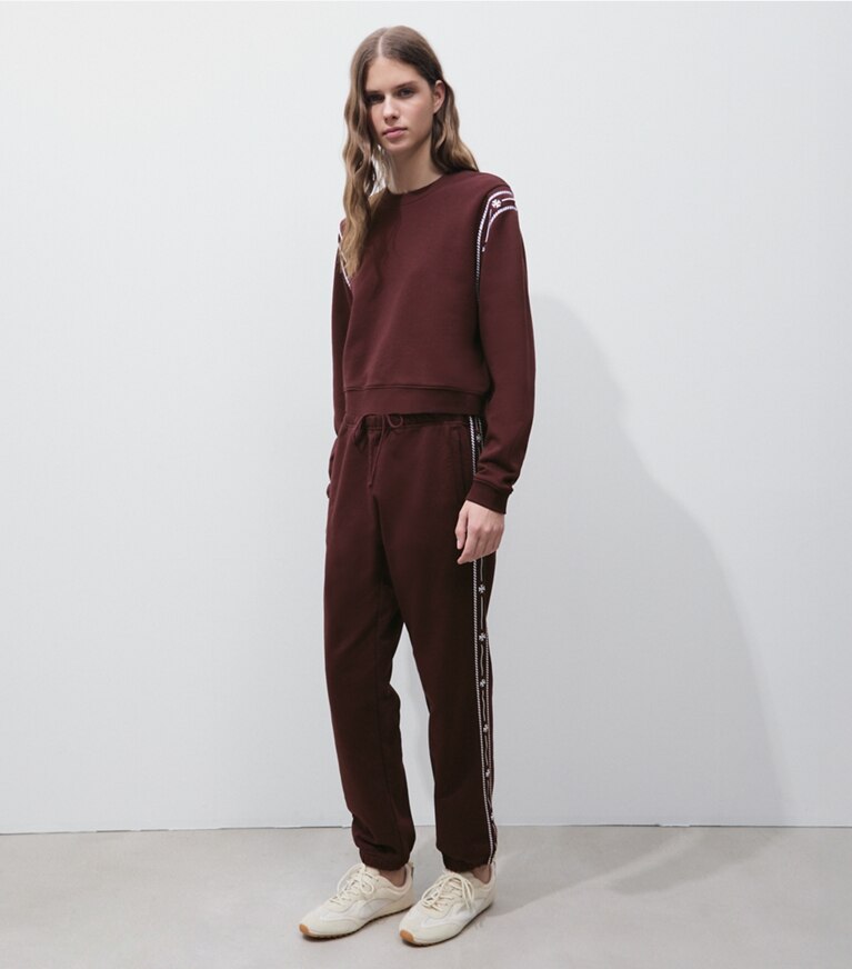 Tory Burch designer bas Pantalon de survêtement en coton bouclette à broderie dans Merlot sur modèle, de face