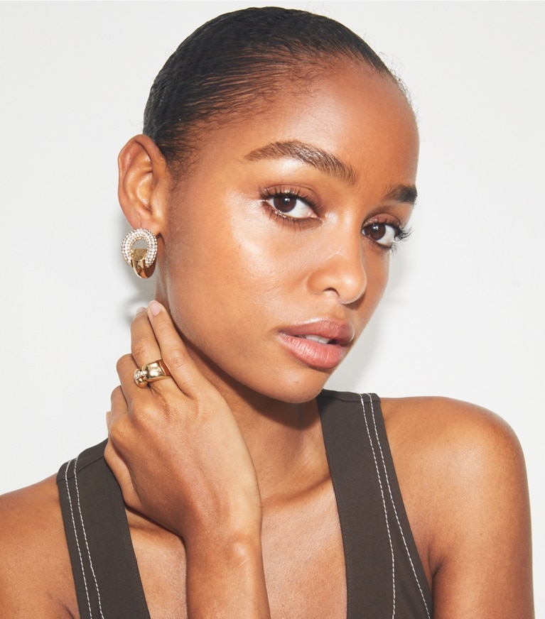 Tory Burch designer earrings Pavé Pierced Hoop Earrings in Light Brass / Crystal accessory on model