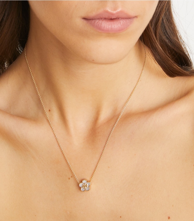 Tory Burch designer collane Pendente con fiore Forget Me Not in Tory Gold / Mother of Pearl accessory on model