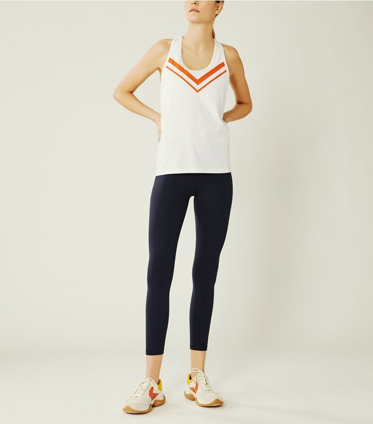 Tory Sport designer tops Performance Chevron Tank in Snow White/Varsity Orange on model front