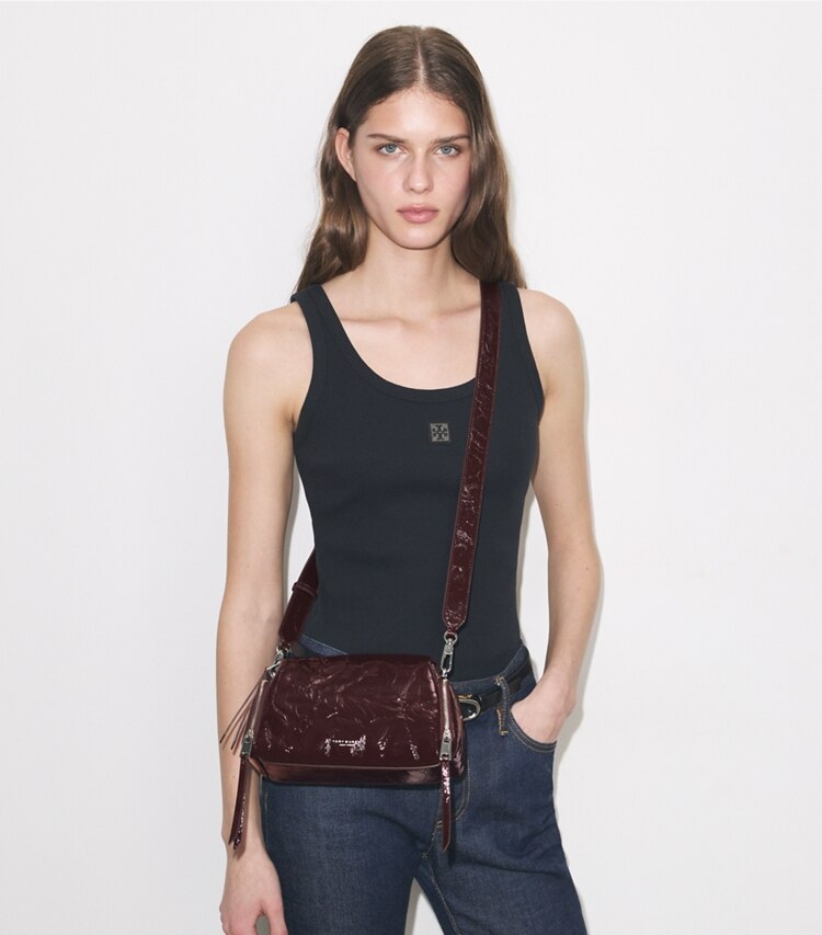 Tory Burch designer クロスボディバッグ ペリー パテント ボイジャー クロスボディバッグ in Albarossa accessory on model