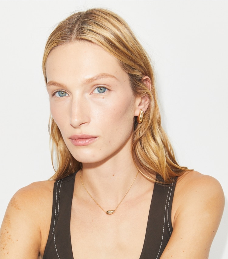 Tory Burch designer colliers Petit pendentif Pierced in Light Brass accessory on model