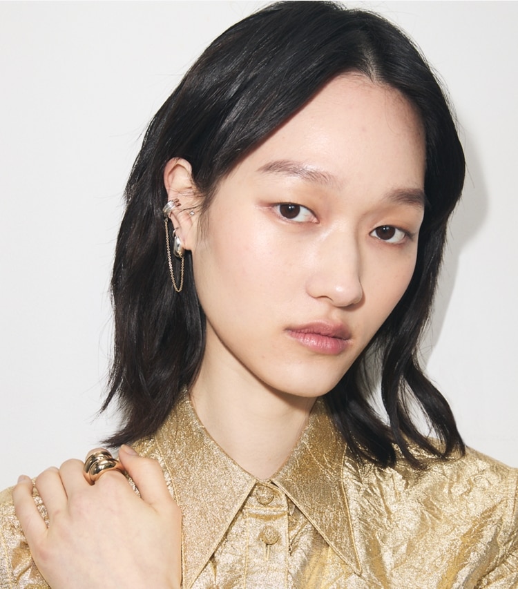 Tory Burch designer earrings Pierced Chain Ear Cuff in Light Brass / Light Silver accessory on model