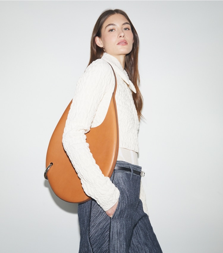 Tory Burch designer ショルダーバッグ ピアス ハンドバッグ in Aged Tan accessory on model