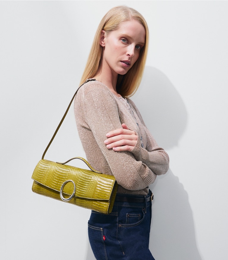 Tory Burch designer clutches Pierced Snake Clutch in Moss accessory on model