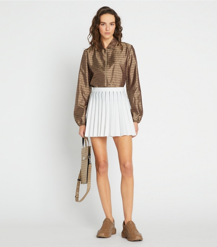 Tory Sport designer bottoms Pleated Tech Knit Skirt in Snow White / Tory Navy on model front