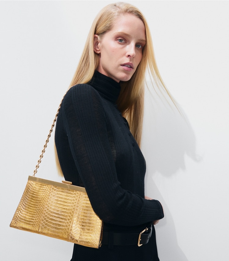 Tory Burch designer pochettes Pochette Gemini Link Frame en cuir de serpent in Gold accessory on model