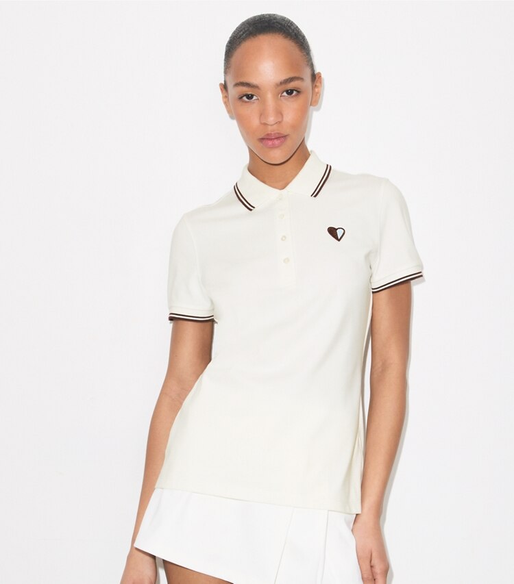 Tory Burch diseñador tops Polo de piqué de alto rendimiento con corazones en Snow White / Dark Merlot detalle en modelo