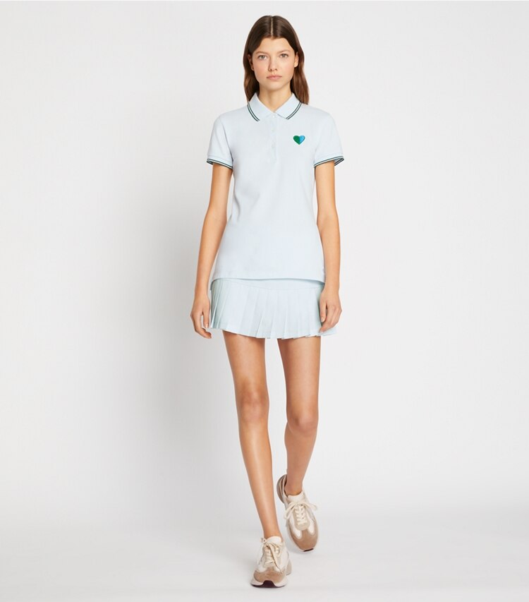 Tory Burch diseñador tops Polo Performance de piqué con corazones en Blue Silk / Blue Silk en el modelo (frente)
