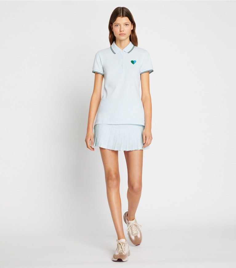 Tory Burch diseñador tops Polo Performance de piqué con corazones en Blue Silk / Blue Silk en el modelo (frente)