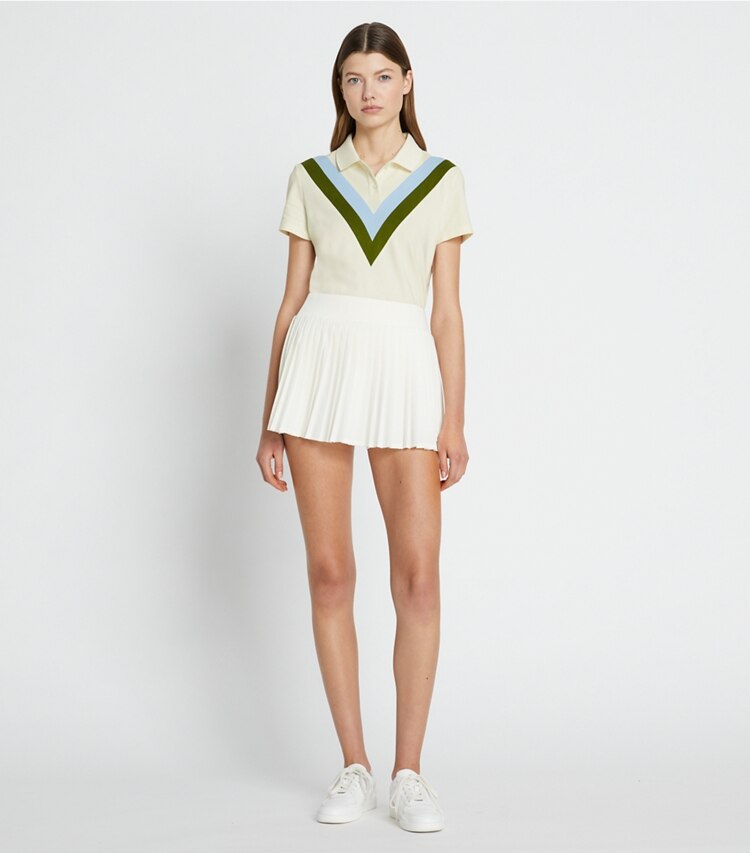 Tory Sport designer hauts Polo performance en piqué à chevrons dans NEW IVORY / Pesto sur modèle, de face