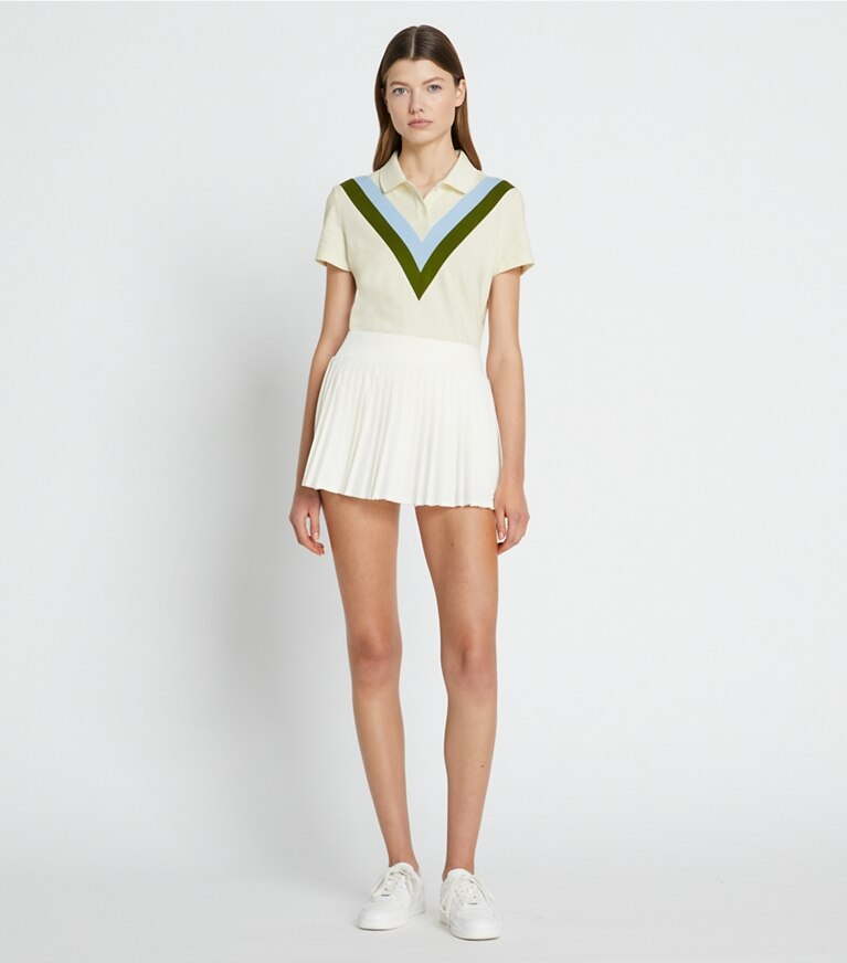 Tory Sport designer hauts Polo performance en piqué à chevrons dans NEW IVORY / Pesto sur modèle, de face