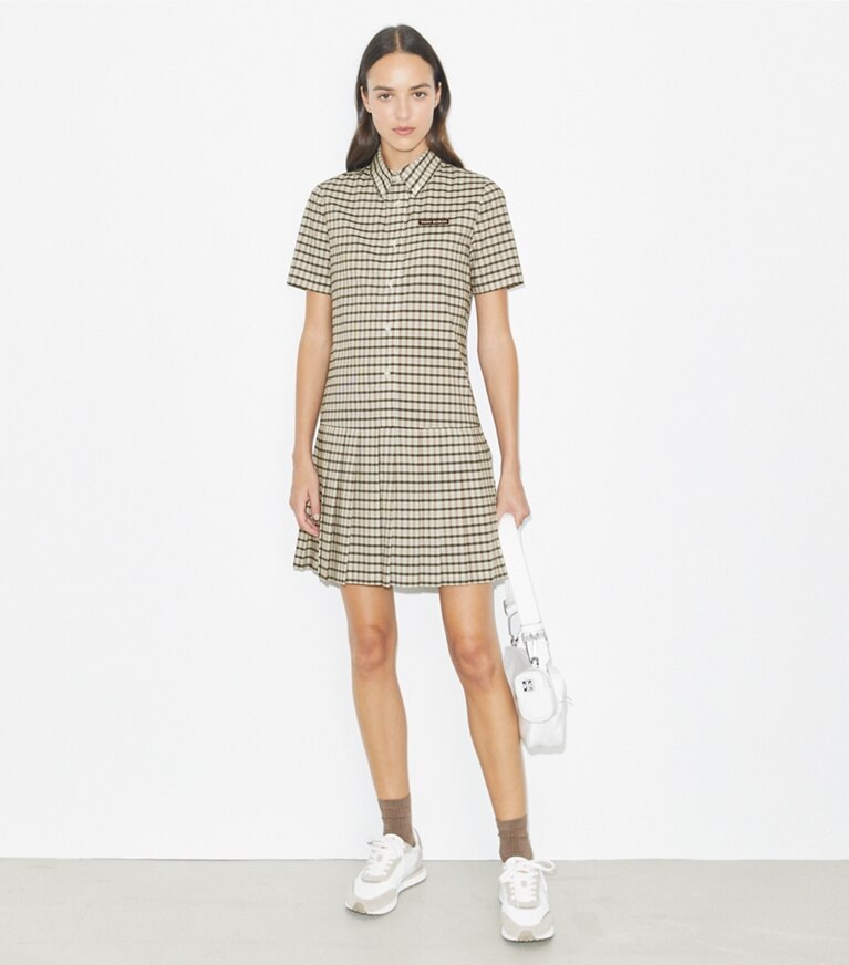Tory Burch designer robes Robe de golf à carreaux, à taille basse et plissée dans Ivory / Black Plaid sur modèle, de face